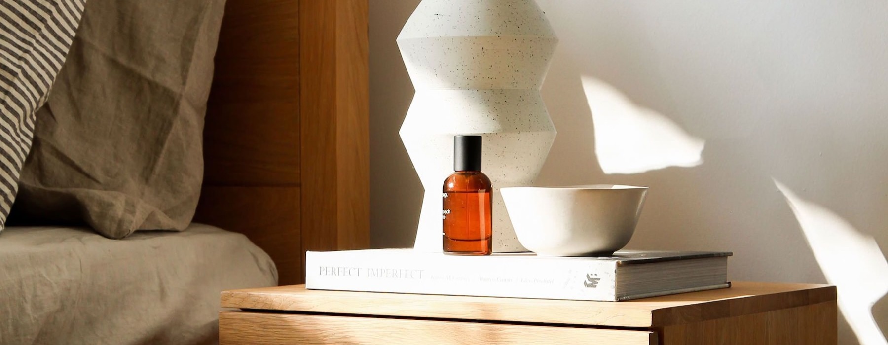 a vase with cotton stems on a bedside table